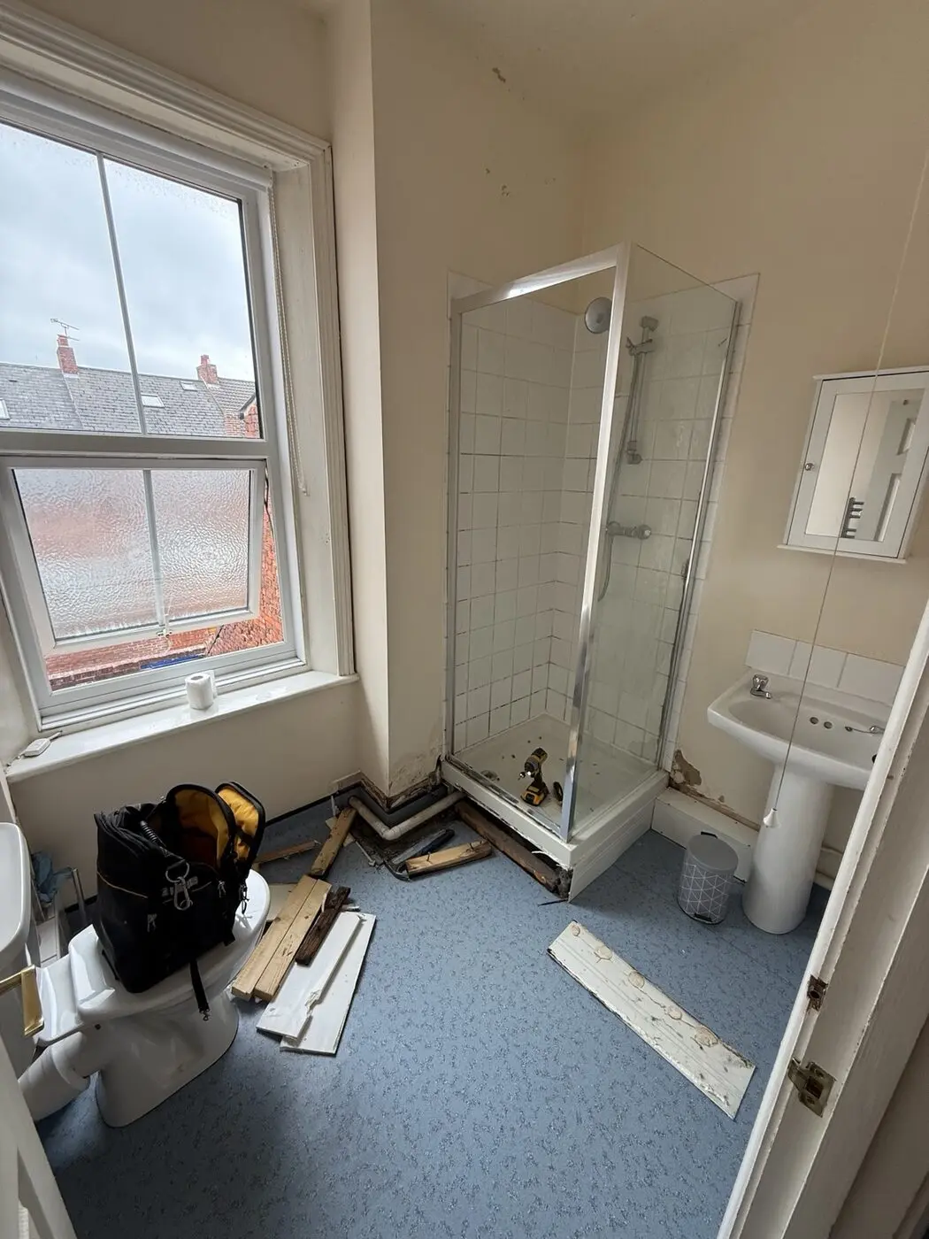 Bathroom renovation in progress with shower tray being installed